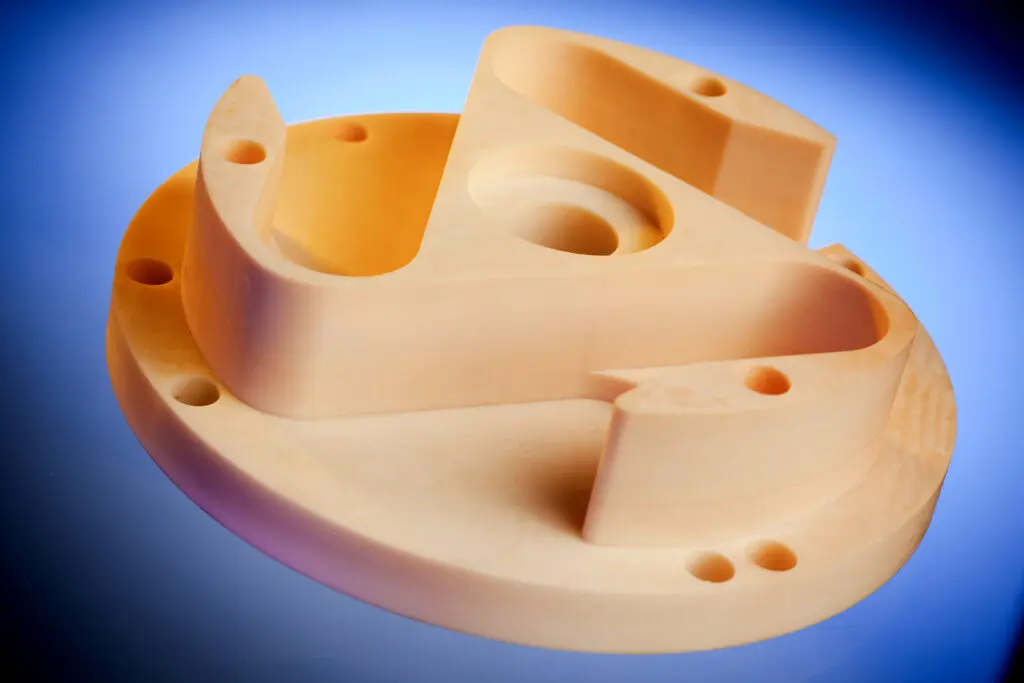 Light-colored 3D-printed mechanical part made from SRBF material, featuring curved shapes on a blue gradient background.