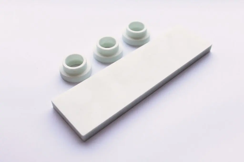 Three white ring-shaped objects made of SRBGF material and a rectangular white block rest on a plain white background.