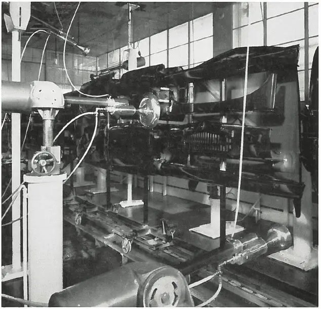 Robotic machinery assembling or inspecting car chassis on an automated automotive factory production line.