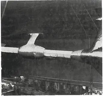 A black and white photo of a futuristic, twin-fuselage aircraft in a hangar.