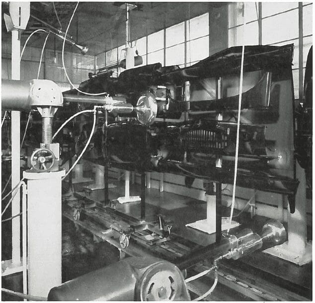 Robotic machinery assembling or inspecting car chassis on an automated automotive factory production line.